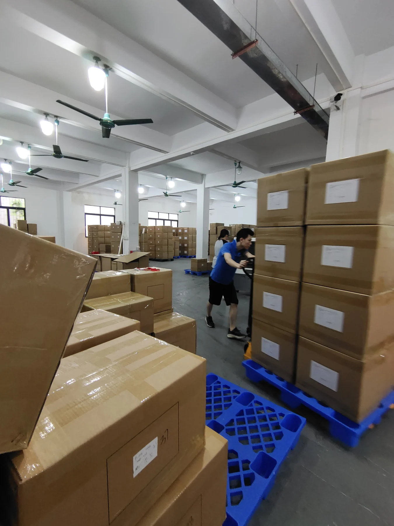 Cartons of finished activewear organized in the MIQI warehouse before shipment