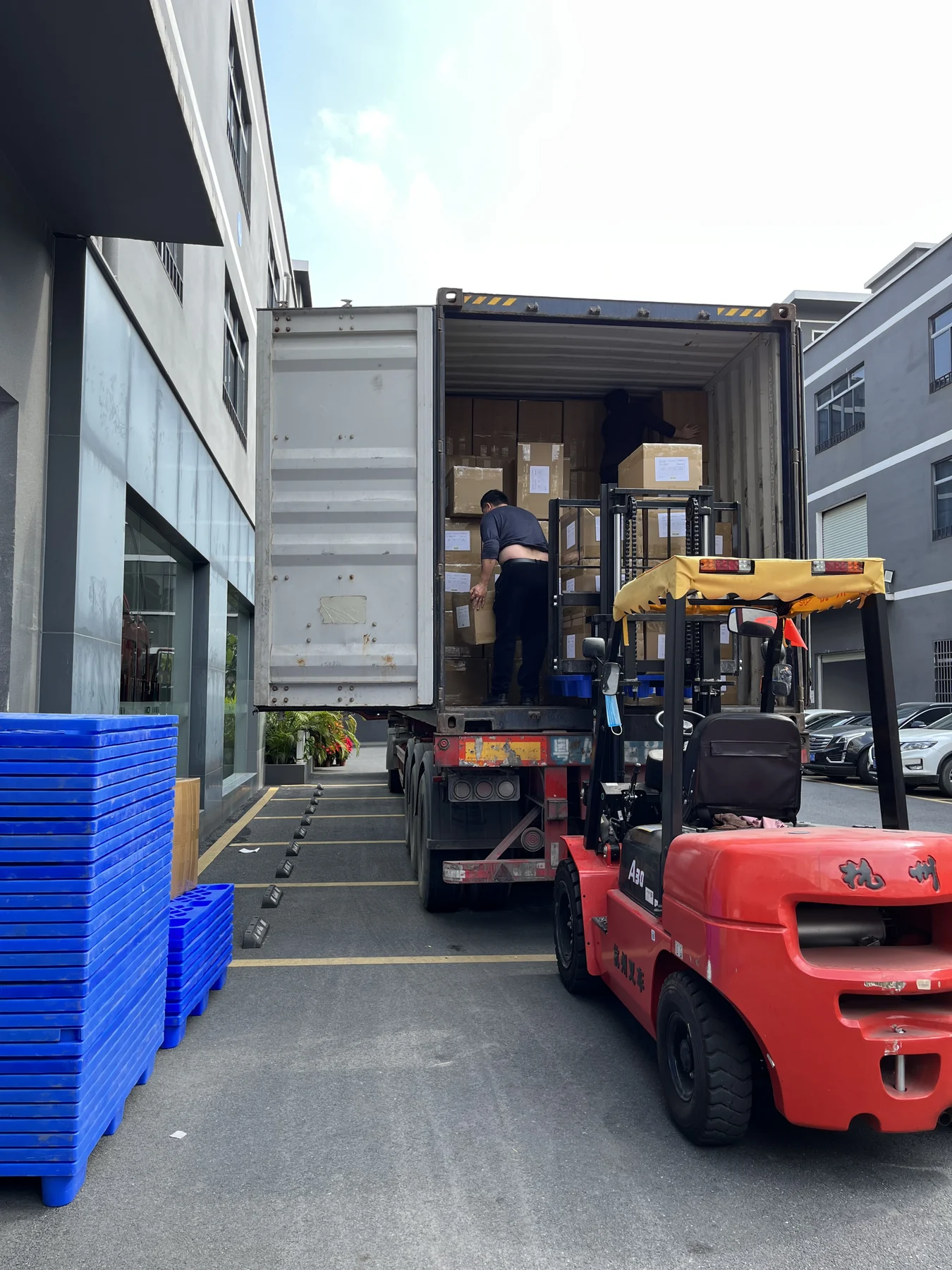 MIQI activewear cartons being loaded into a shipping container at the factory