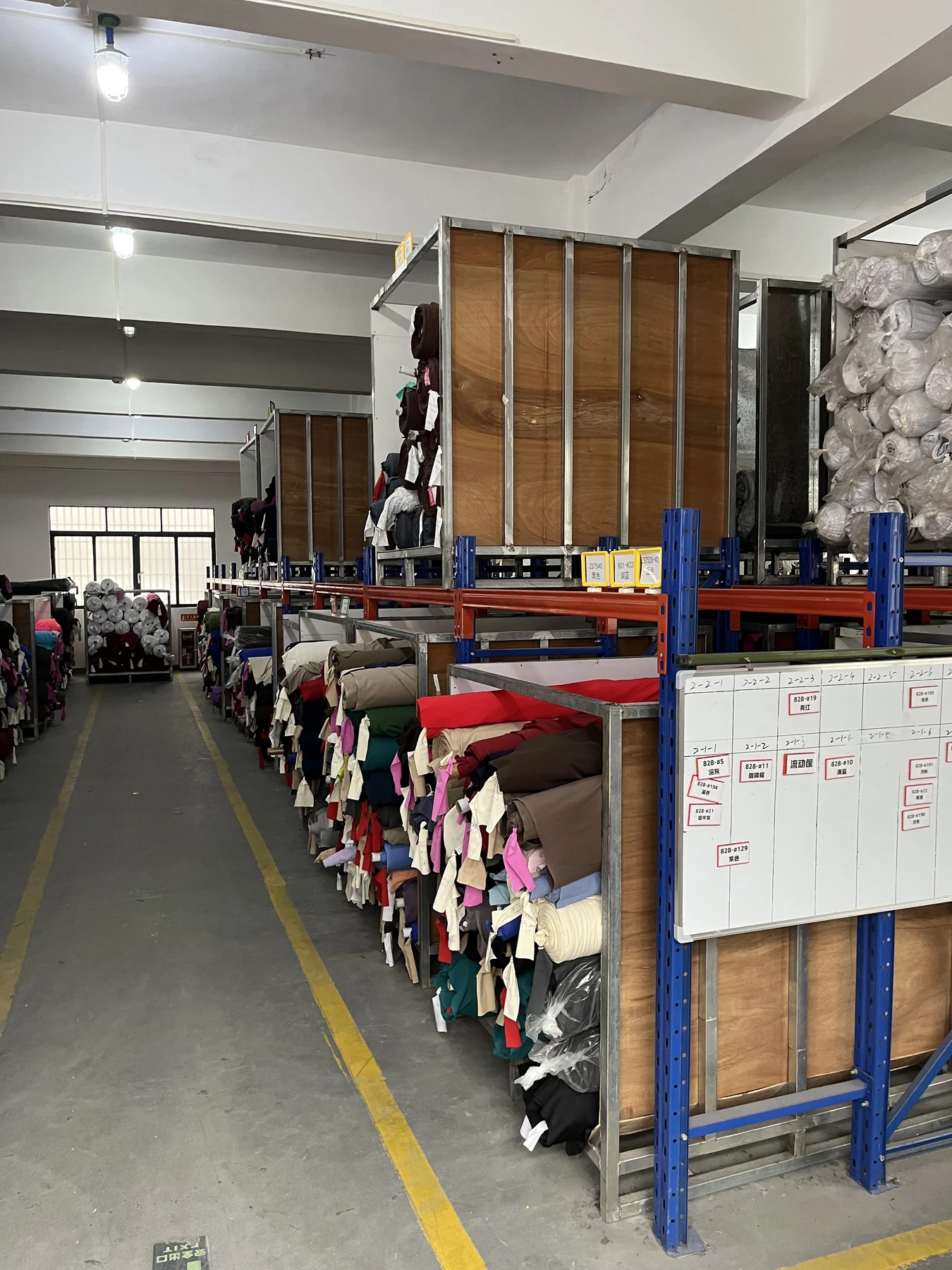 MIQI fabric warehouse with activewear fabric rolls arranged for material selection