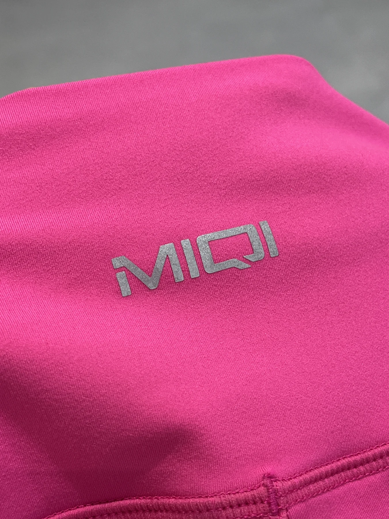 MIQI heat-transfer logo applied to pink activewear fabric