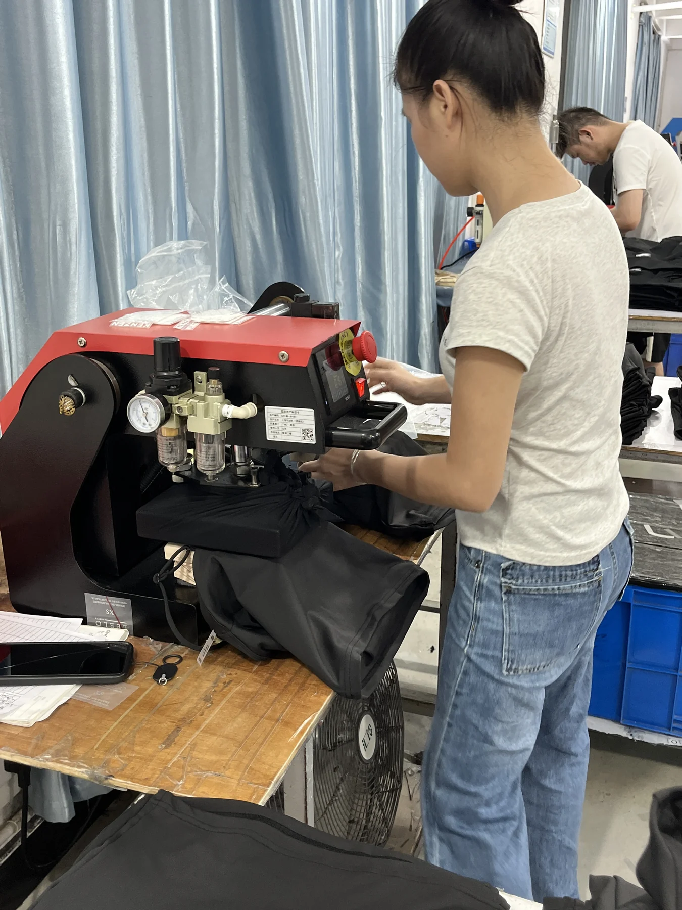 MIQI operator applying a logo to activewear during production
