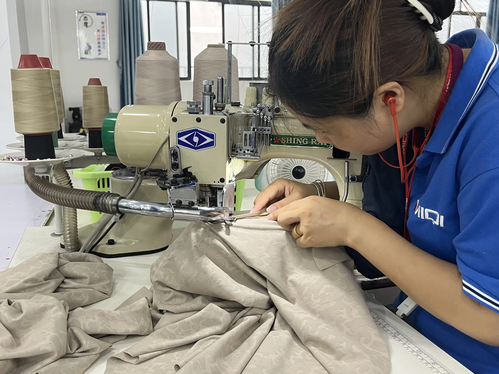 MIQI sewing operator using specialized activewear sewing equipment