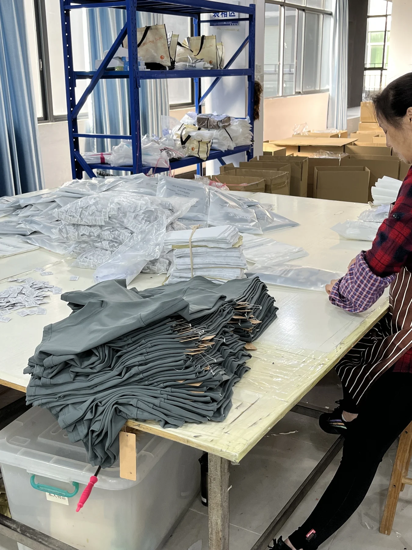 MIQI team packing finished activewear garments at the factory