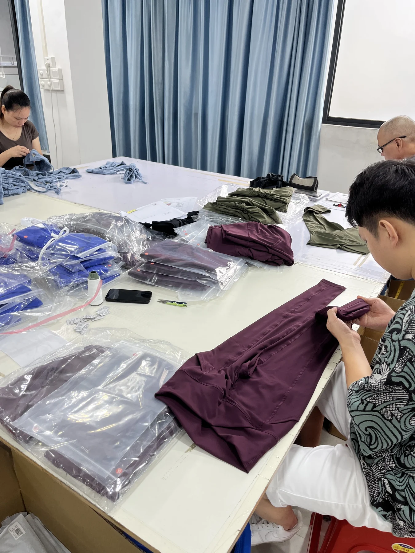 MIQI team reviewing activewear samples and workmanship